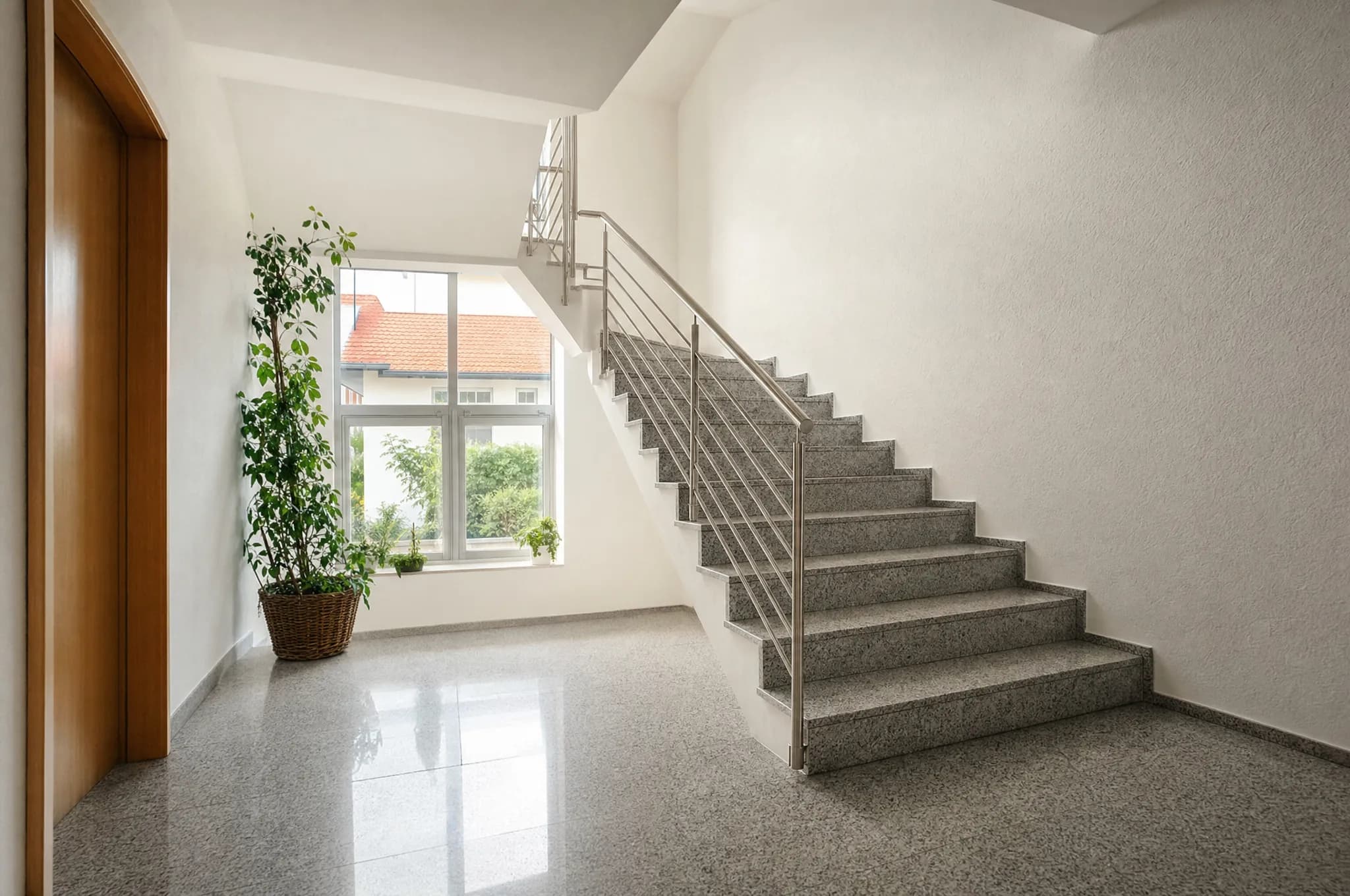 Gepflegtes, helles Treppenhaus eines Mehrfamilienhauses mit sauberem Handlauf